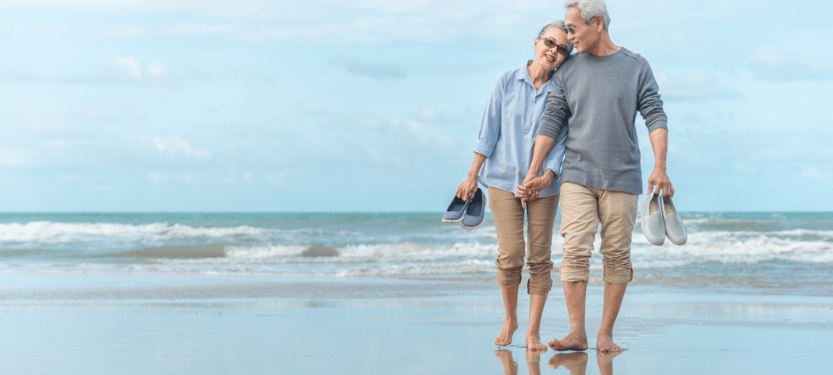 Older couple walking on beach