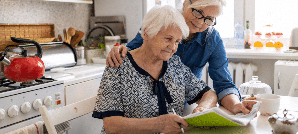 Mature woman helping elderly mother with paperwork