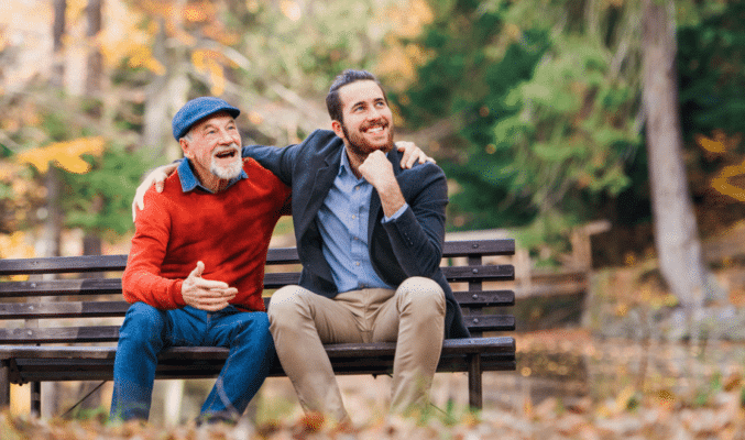 Father & son sitting on bench in Autumn